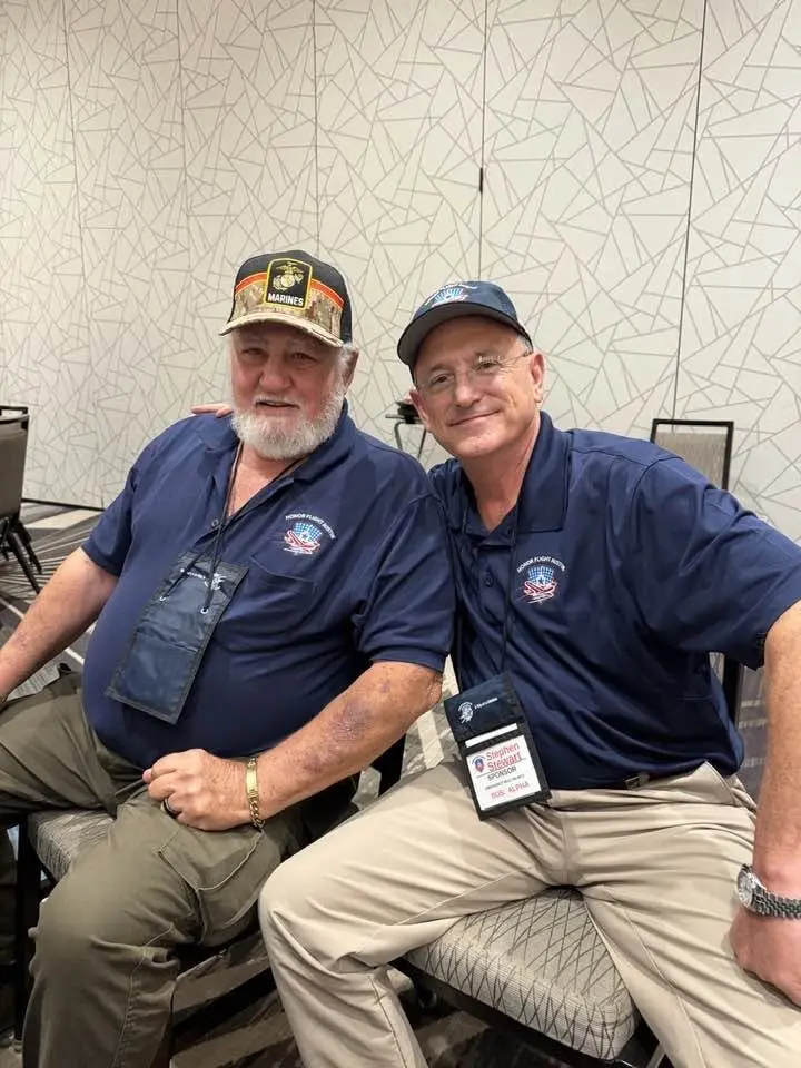 Stephen Stewart seated with a veteran during Honor Flight Austin Flight 107