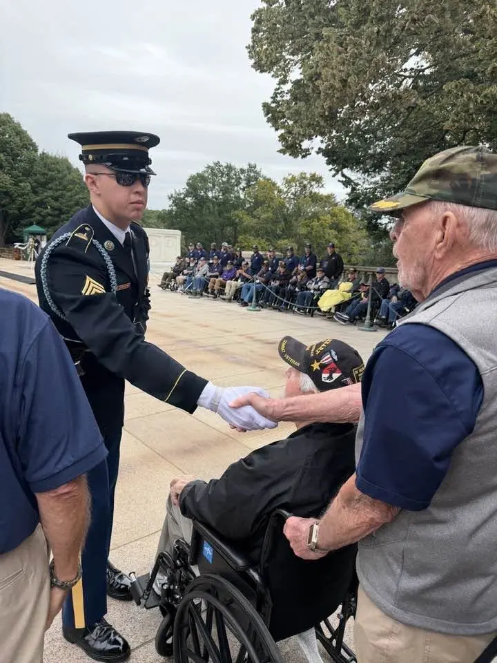 A soldier greets a veteran at the Tomb of the Unknown Soldier wreath-laying ceremony during Honor Flight Austin Flight 107