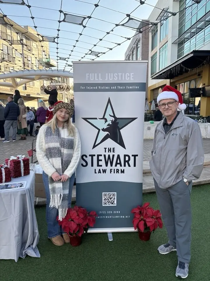Stephen Stewart and Jordan at The Stewart Law Firm sponsor booth at the 2025 Austin Jingle Bell 5K